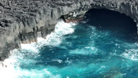 Cave in coast line with waves Stockbeeldmateriaal 249202036