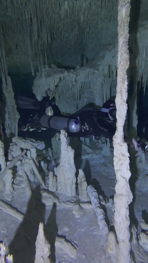 Cave divers swim through a small restriction Stock Footage 277230232