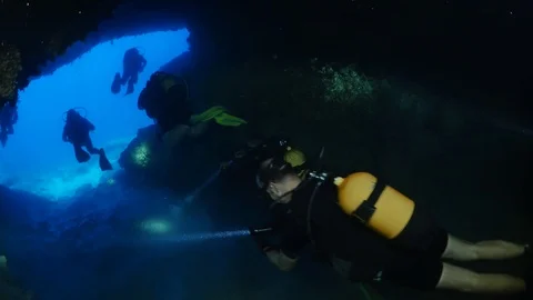 Cave diving underwater scuba divers exploring cave dive Stock Footage