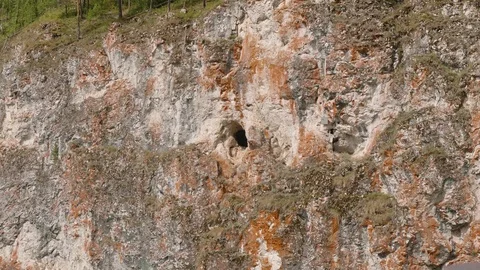 Cave in the middle of cliff over the river. Old sweater and plate is near it Stock Footage 122685227