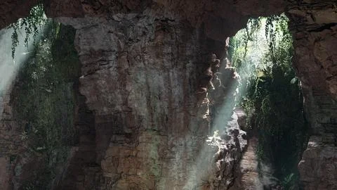 A cave with sunlight coming through the rocks 스톡 일러스트