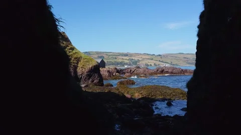 Cave wall, exiting the cave towards ocean coast beautiful view 2.7k Video stock 209189006
