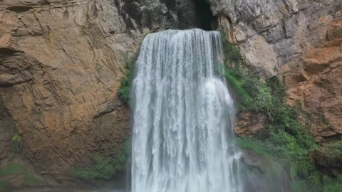 Cave waterfall landscape between 100 meters cliffs Stock Footage 311742807