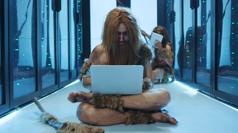 Caveman of ancient neanderthals using laptop like modern engineer at server Stock Footage 120748637