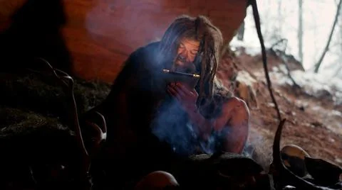 Caveman using tablet computer learning new things in ancient dwelling Stock Photos