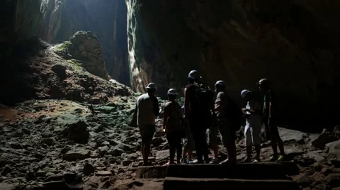 Cavers group in deep dark cavern, bright opening ceiling ahead Stock Footage 50601162