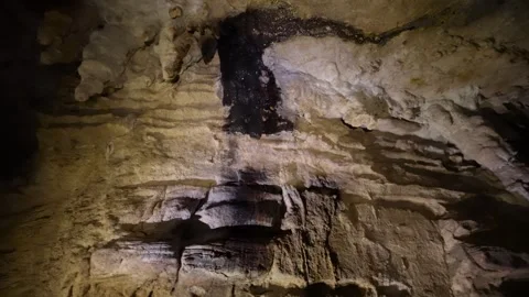 Cavers with headlamps exploring inside a dark cave Stockbeeldmateriaal 334934480