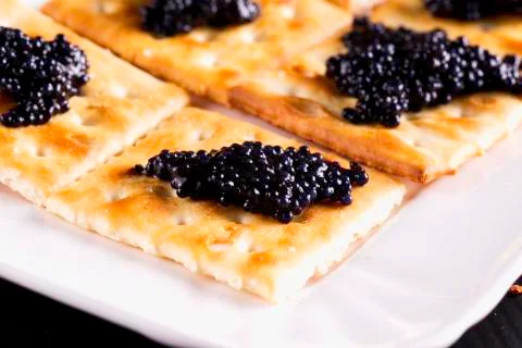Caviar over crackers Stock Photos