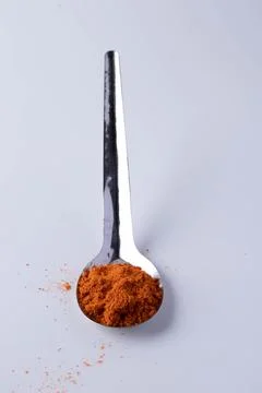 Cayenne pepper in a spoon on a white background Stock Photos