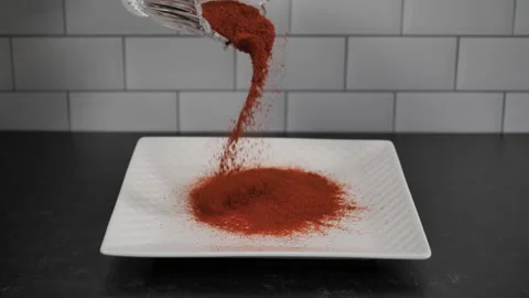 Cayenne pepper is sprinkled onto a white platter. Stock Footage 140267912