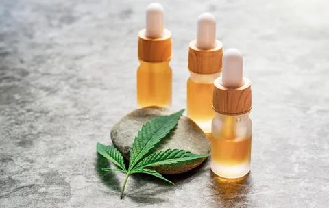 CBD or THC full spectrum medical Cannabis oils on stone table with Hemp leaf  Stock Photos
