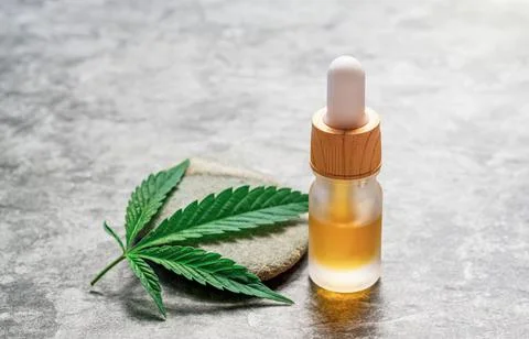 CBD or THC full spectrum medical Cannabis oil on stone table with Hemp leaf c Stock Photos
