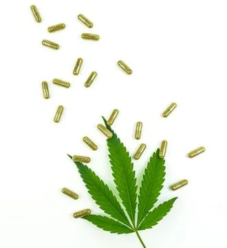 CBD pills. Group of clear CBD Cannabidiol capsules and hemp leaf isolated Foto stock