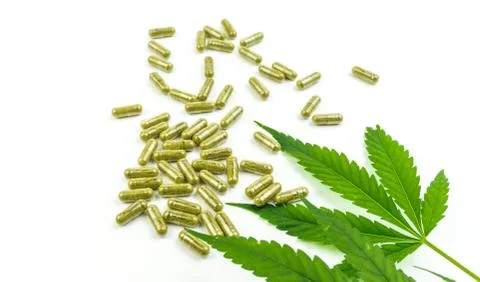 CBD pills. Group of clear CBD Cannabidiol capsules and hemp leaf isolated on  Stock Photos