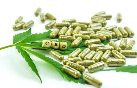CBD pills. Group of clear CBD Cannabidiol capsules and hemp leaf isolated Stock Photos