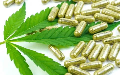 CBD pills. Group of clear CBD Cannabidiol capsules and hemp leaf isolated on  Stock Photos