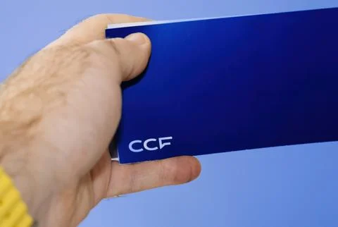 CCF cheque booklet in hand on blue background......... Stock Photos