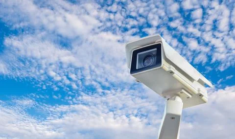 CCTV camera on bright blue sky background, Concept. 24 hour day and night s.. Stock Photos