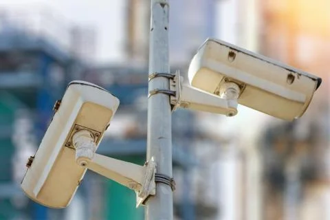 CCTV camera concept with refinery on background Stock Photos