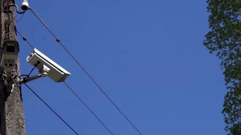 CCTV camera hanging on a pole on blue sky background Stock Footage 75447126