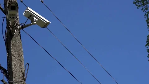 CCTV camera hanging on a pole on blue sky background Stock Footage 75447143