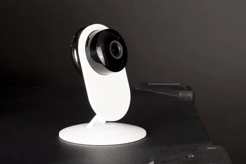 CCTV camera lens, security camera on a black background in a room on furnitur Stock Photos