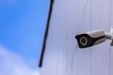 CCTV camera on modern building. Security camera on wall. Copy space. Stock Photos