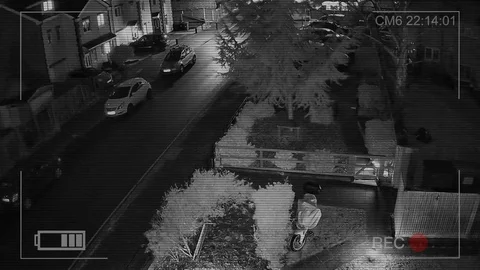 CCTV camera or surveillance system is in operation on garden, car park at night Stock Footage