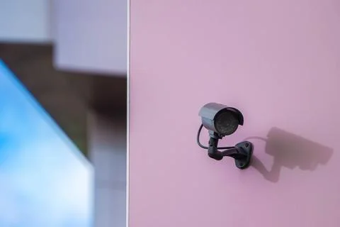 CCTV camera on pink wall in modern city Stock Photos