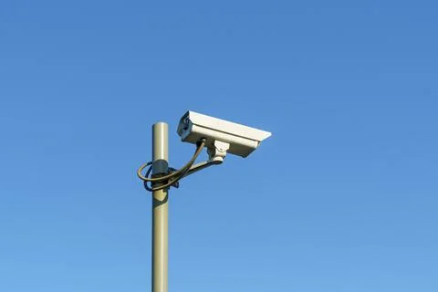 CCTV camera on pole on clear blue sky background for law and order Stock-Fotos