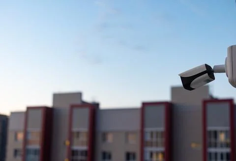 CCTV camera on the roof of a multi-level parking lot with a residential bui.. Stock Photos