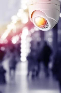 Cctv camera security system on a ceiling of a shopping mall blurred backgroun Stock Photos