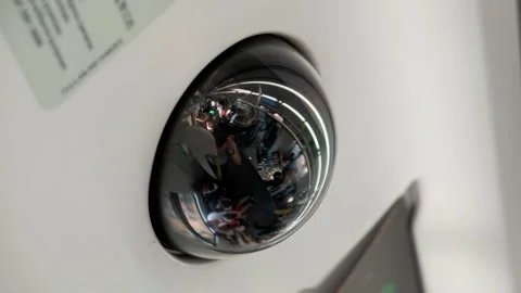 CCTV camera in train cabin, reflection on the camera cover of people in train Stock Footage 274868334