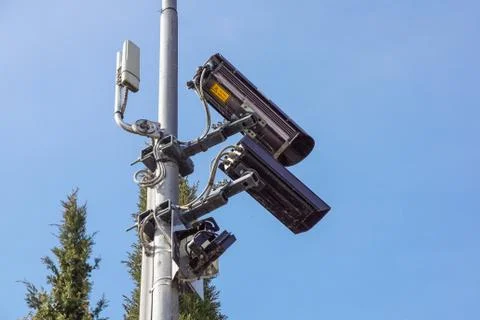 CCTV security camera and surveillance on a pole against the backdrop of blue sky Stock Photos