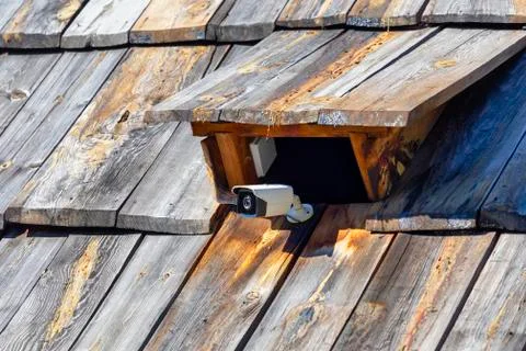 Cctv security camera attached on the old old wooden roof tile Stock Photos