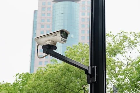 CCTV security camera on black pole with skyscraper background Foto stock