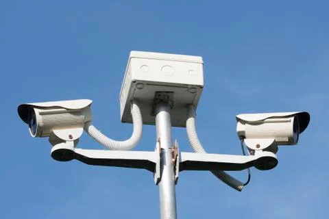 Cctv security camera on blue background, property protection Stock Photos