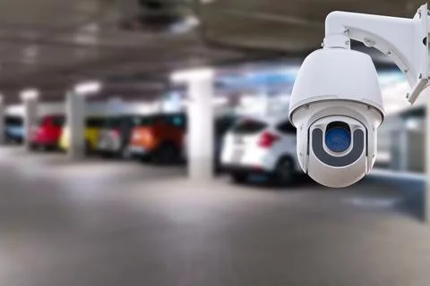 CCTV security camera on blur car parking. Copy space. Stock Photos