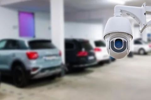 CCTV security camera on blur car parking. Copy space. Stock Photos