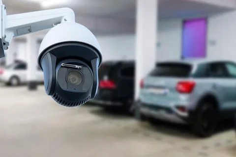 CCTV security camera on blur car parking. Copy space. Stock Photos