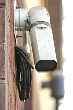 CCTV security camera on brick building watching the area Foto stock