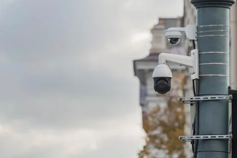 CCTV security camera on classic building in town background, cloudy sky for c Foto stock