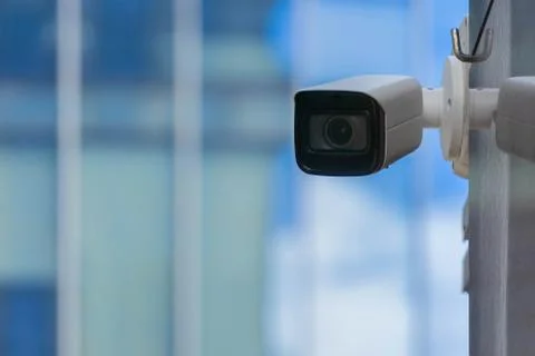 CCTV security camera on modern building wall in city Stock Photos