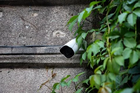 CCTV security camera mounted on a textured stone wall Stockfoto's