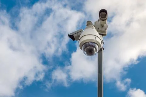 CCTV security cameras on pole on blue sky with white clouds background Stock Photos