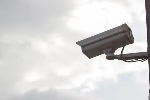 CCTV security video camera protect on the clouds and sky background. Stock Photos