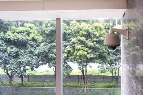 CCTV system in the office building, trees background Stock Photos