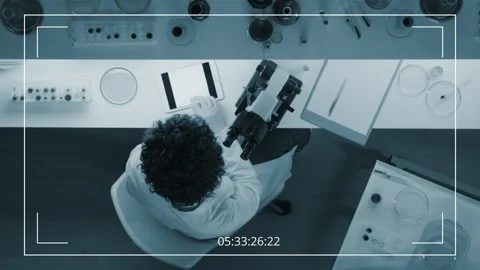 CCTV Top View of Scientist Looking Through the Microscope in Lab Stock Footage 275008629