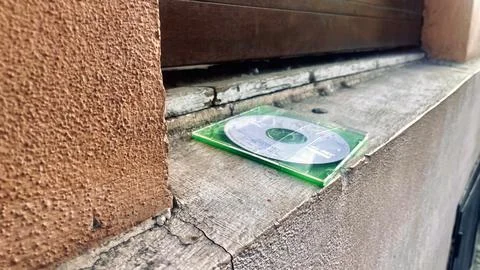 CD case sitting on ledge outside a building during daytime in an urban area 스톡 사진