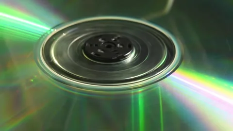 CD disc spinning and stopping under light, reflecting rainbow colors evoking Video stock 305573797